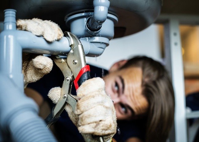 Plumber fixing the sink